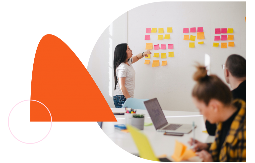 Woman working on whiteboard with sticky notes